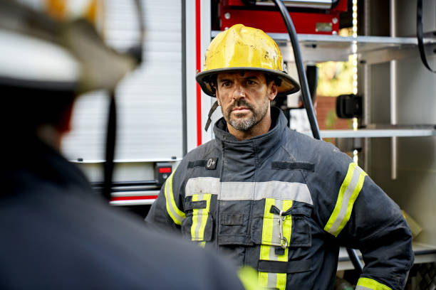 istock Mid 40s Bearded Firefighter Looking at Teammate 1313773515