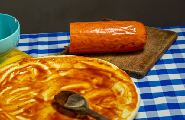 istock Pizza dough with tarantella sauce being spread over a wooden spoon 1313774810