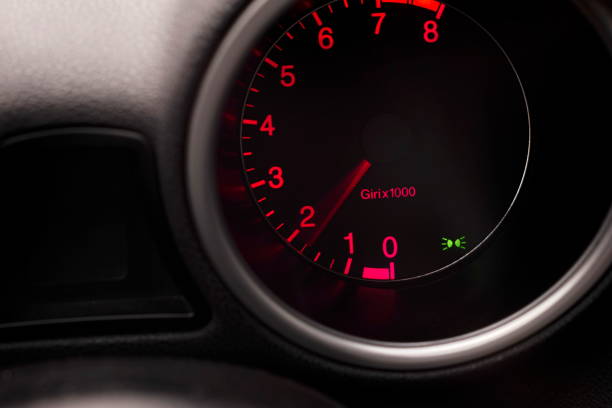 istock Car dashboard tachometer rev counter with red background lighting  and needle 1313780815