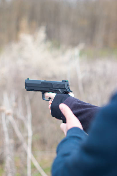 istock Young female arms and hands aiming a hand gun in self-defence training target practice unrecognizable 1313780850