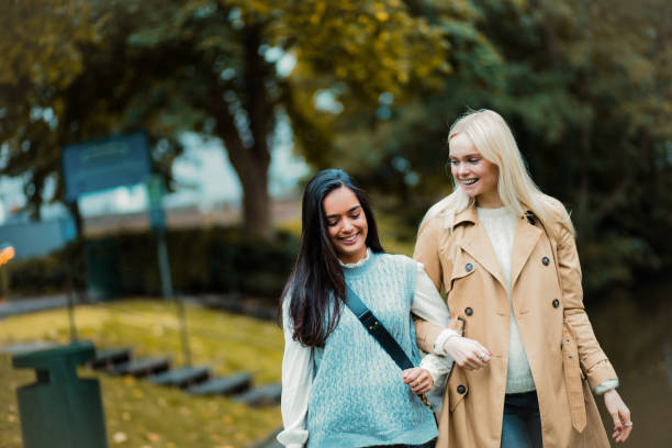 istock Two young girls walking trough park and talking. 1313781671
