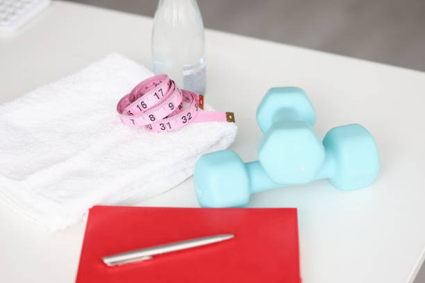istock Fitness dumbbells with centimeter and towel lie on table 1313782524