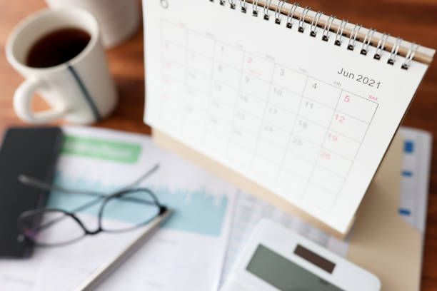 istock Calendar for June calculator and cup of tea is on table 1313782539