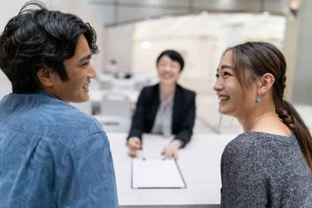 Asian married couple consulting with agent