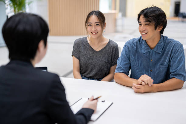 Asian married couple consulting with agent
