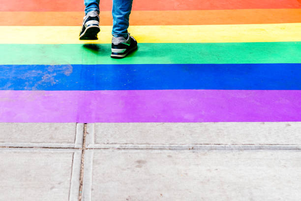 istock Feet Walking on Sidewalk Decorated with Rainbow Flag 1313782767