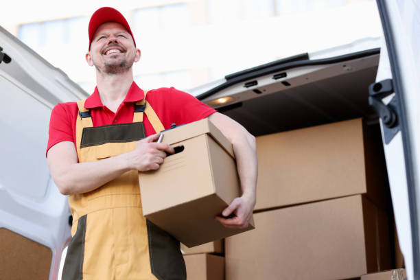 istock Smiling male courier holding large cardboard box 1313783652
