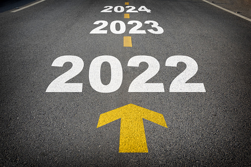 Año nuevo 2022 a 2024 y flecha amarilla en carretera asfaltada photo