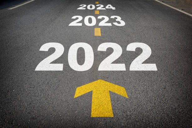 nouvel an 2022 à 2024 et flèche jaune sur route asphaltée - forecasting photos et images de collection