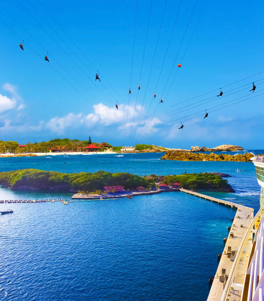 People flying at high zipline on caribbean People flying at high zipline on caribbean at Labadee island at Haiti. The arial view from desck of abstract cruise ship at caribbean Haiti at sunny morning. Collage labadee stock pictures, royalty-free photos & images