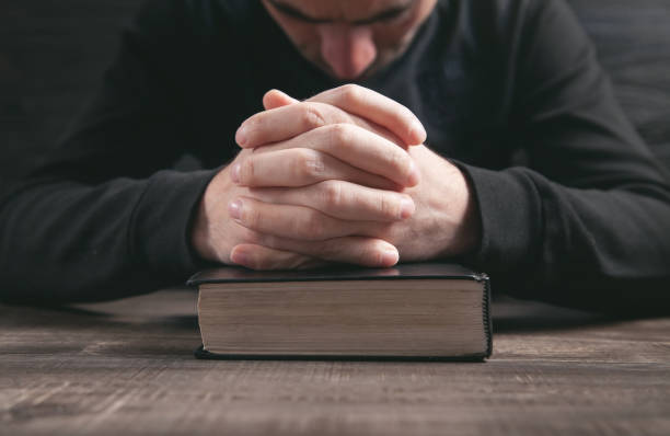istock Caucasian man praying in the dark room. 1313784657