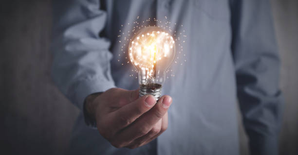 istock Man holding light bulb and human brain. Brainstorming. Idea 1313784828