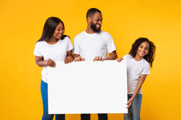 istock Afro family holding blank white advertising billboard at studio 1313786013