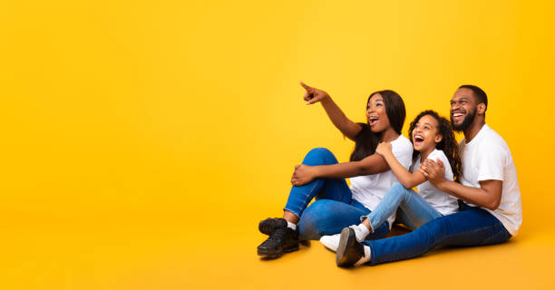 istock Smiling black family pointing aside at free copy space 1313786751