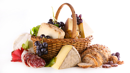 wicker basket with bread,  cheese and salami on white background