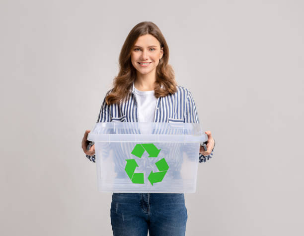 istock Smiling Young Woman Holding Empty Plastic Container With Green Recycle Sign Icon 1313786886
