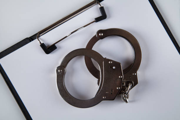 istock Handcuffs, a blank sheet of paper on the table. 1313787133