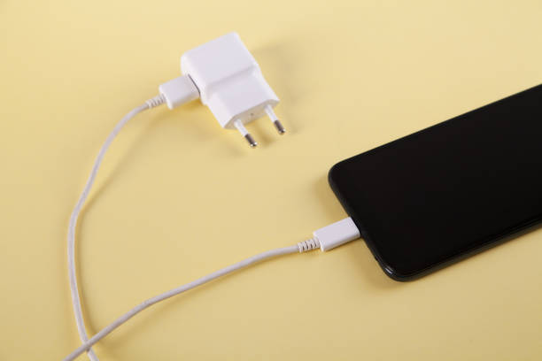 istock Mobile smartphone with charging on yellow background. 1313787140