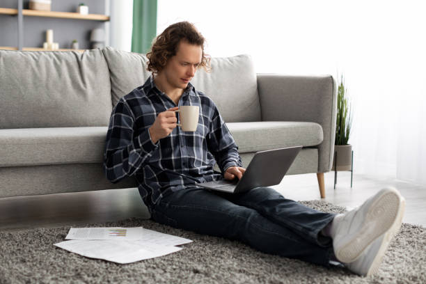 istock Guy Using Laptop Working Online Drinking Coffee Sitting At Home 1313787227