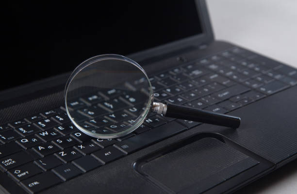 istock Magnifying glass is located on the keyboard. Black color computer and magnifying glass. 1313787277
