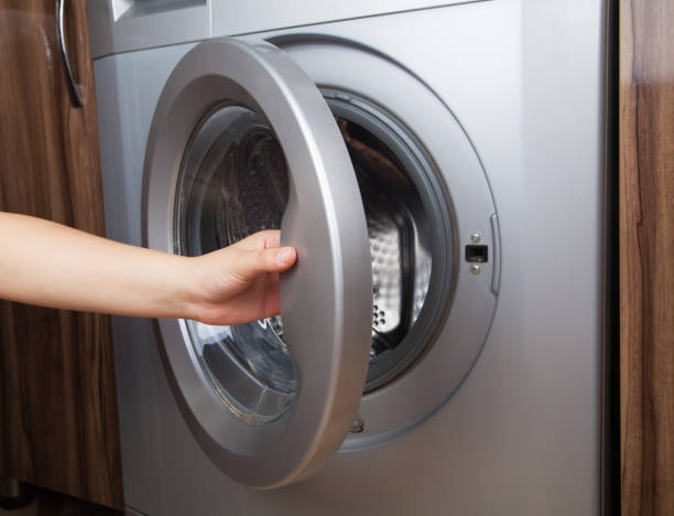 istock Woman using washing machine. Washing machine at home. 1313787281