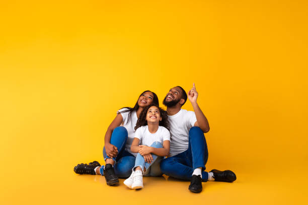 istock Smiling black family pointing up at free copy space 1313787492