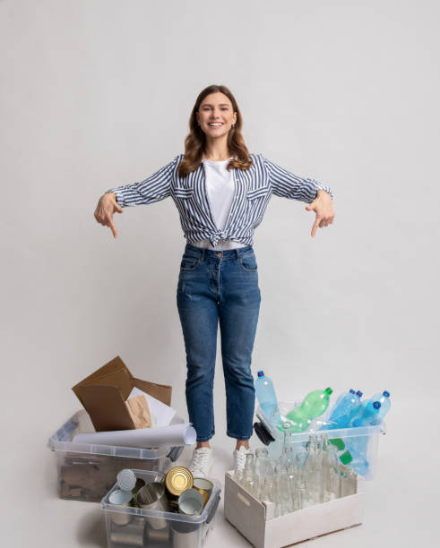 istock Young lady sorting waste, pointing at containers with different kind of garbage 1313787613