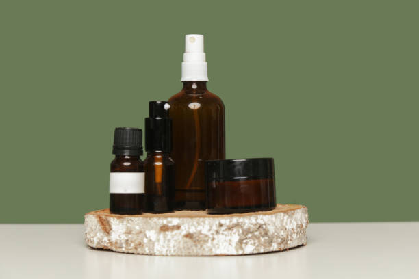 istock Various brown glass cosmetics bottles on green background 1313787784