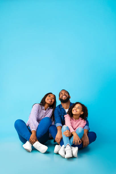 istock Smiling black family looking up at free copy space 1313788518