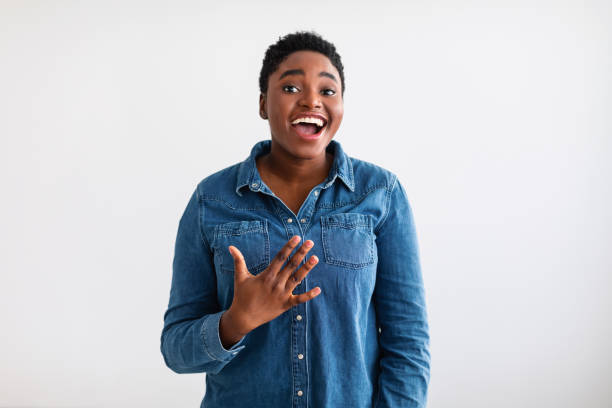 Portrait of casual young black woman laughing, white wall