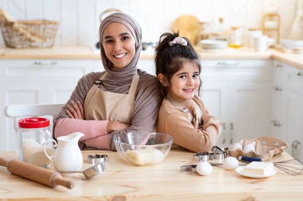 istock Happy Islamic Mom And Little Daughter Posing In Kitchen While Baking Together 1313790251