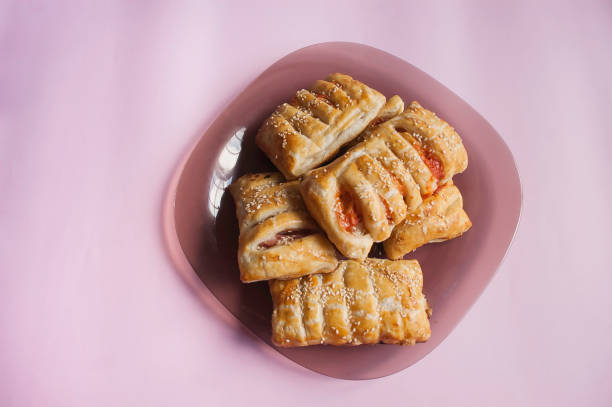 cooking baking confectionery oven puffs dough sausage in dough pink background