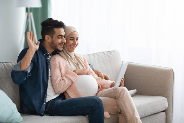 istock Joyful Expectant Muslim Spouses Making Video Call With Digital Tablet At Home 1313790477