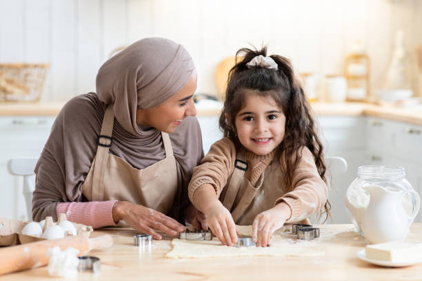 istock Adorable Little Arab Girl Having Fun While Baking With Mother In Kitchen 1313790588