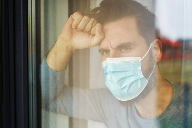 istock Close up of man in mask looking through the window 1313790730