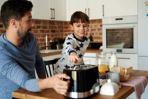 istock Smiling boy waiting for toasts from a toaster 1313790902