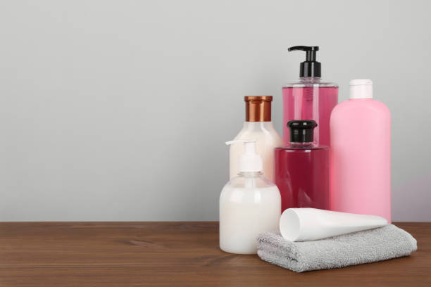 istock Different shower gel bottles with towel on wooden table. Space for text 1313792438