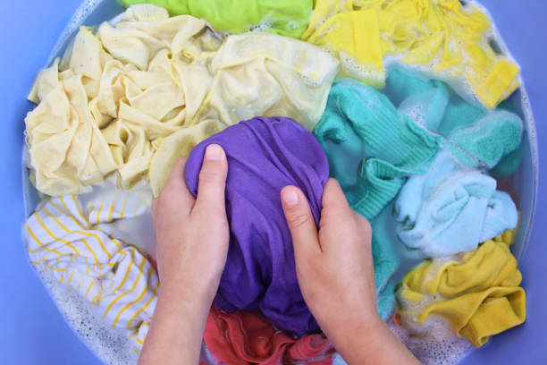istock Female hands wash colored clothes in basin. Top view. 1313792633