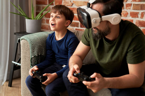 istock Father wearing VR glasses playing with son at home 1313793496