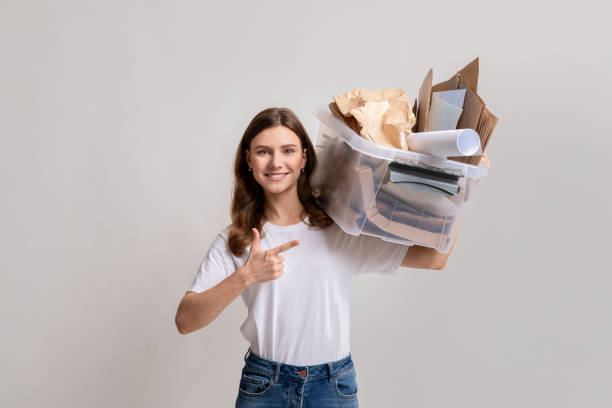 istock Paper Waste Recycle. Millennial Lady Holding Plastic Container Filled With Cardboard Trash 1313794108