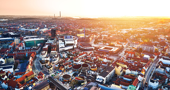 Odense city. Drone point of view from town square. Early morning dawn. Sunrise gives extra warmth to the red rooftops. Area with new buildings in the center