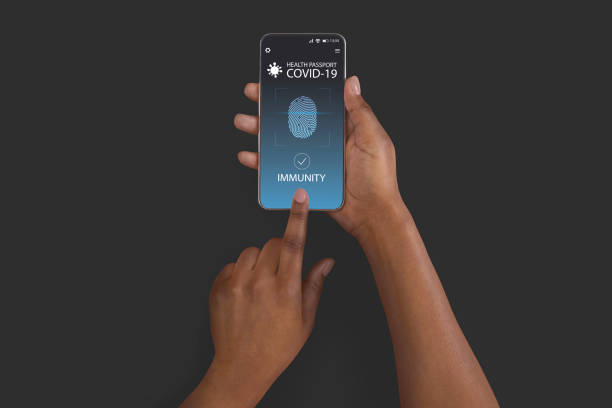 istock Black lady using smartphone with digital immune e-passport for covid-19 1313795211