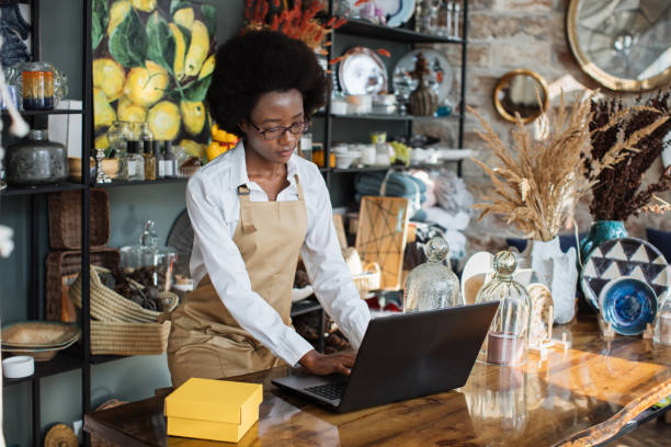 istock Competent saleswoman using laptop for work at decor shop 1313796134