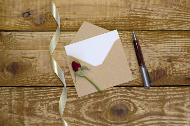 istock Simple small envelope with space for writing on wooden background with pen Narrow focus line, shallow depth of field 1313796944
