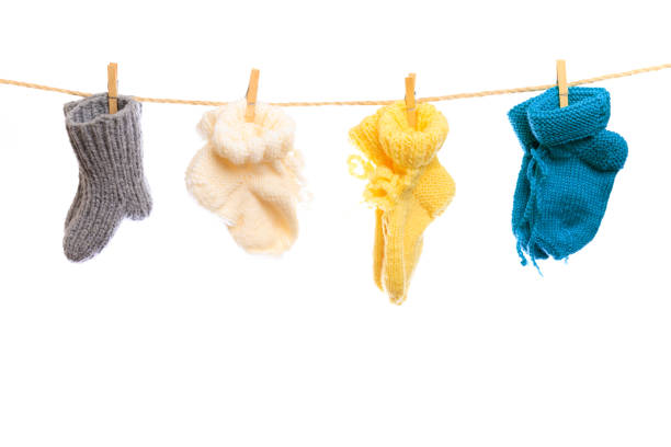 Baby clothes on a clothesline on white  background . knitted socks- Image