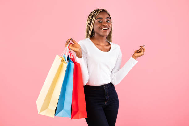 istock Black lady holding shopping bags at pink studio 1313797461