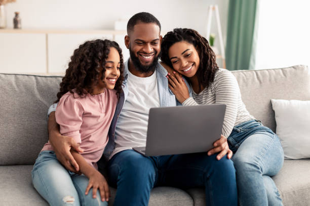 istock Happy afro family using laptop sitting on the couch 1313798094