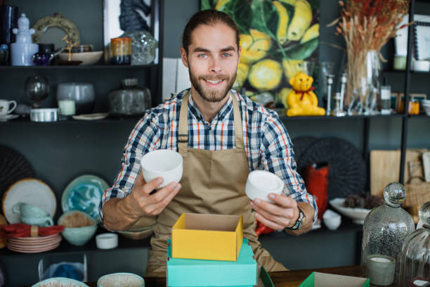 istock Smiling bearded man sitting at counter at decor store 1313799150