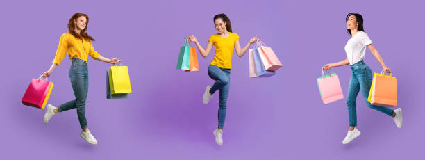 istock Young diverse ladies walking with bags at purple studio 1313799297