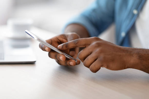 istock Cropped Image Of Unrecognizable Black Man Using Smartphone While Sitting At Desk 1313800063